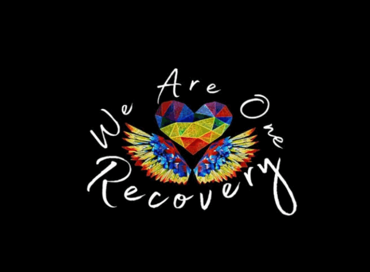 Colorful heart with wings surrounded by the text "We Are One Recovery" on a black background, symbolizing unity and healing.