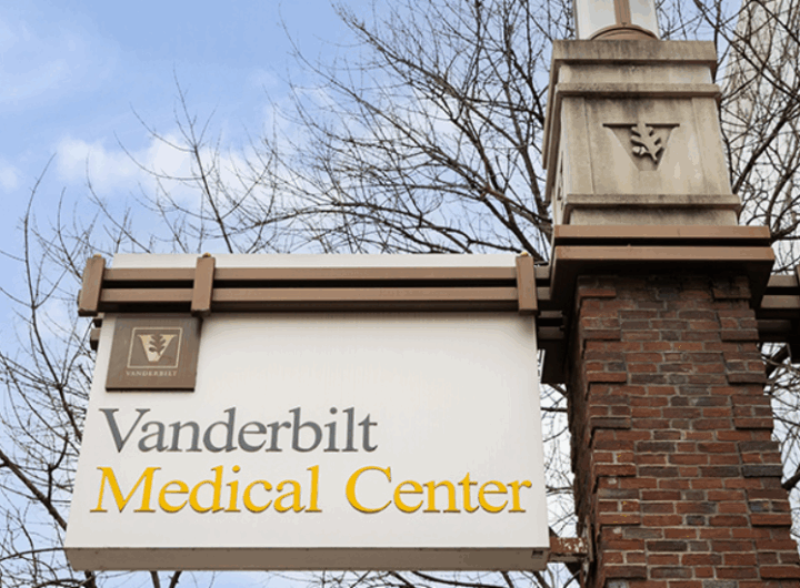Sign for Vanderbilt Medical Center, featuring logo and name with a clear blue sky and bare trees in the background.