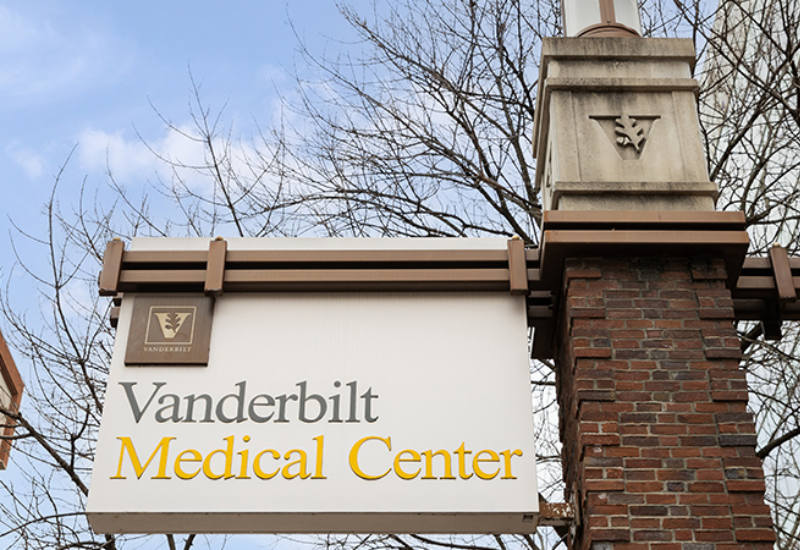 Sign for Vanderbilt Medical Center, featuring logo and name with a clear blue sky and bare trees in the background.